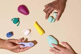 hands holding colorful vibrating motorized sex toys