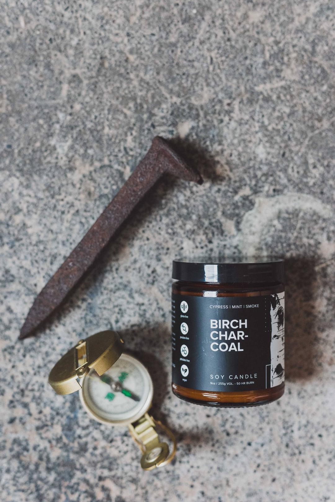 flat lay manly birch candle with pocket watch and iron 