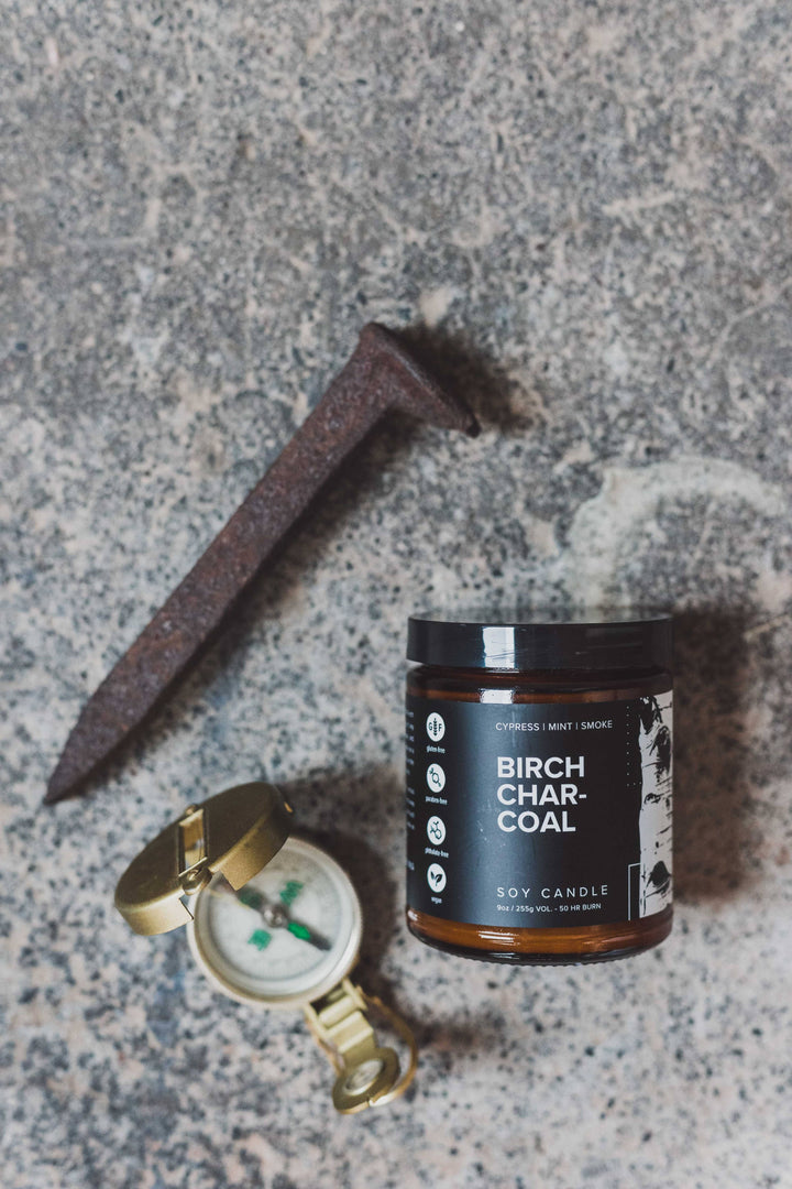 flat lay manly birch candle with pocket watch and iron 