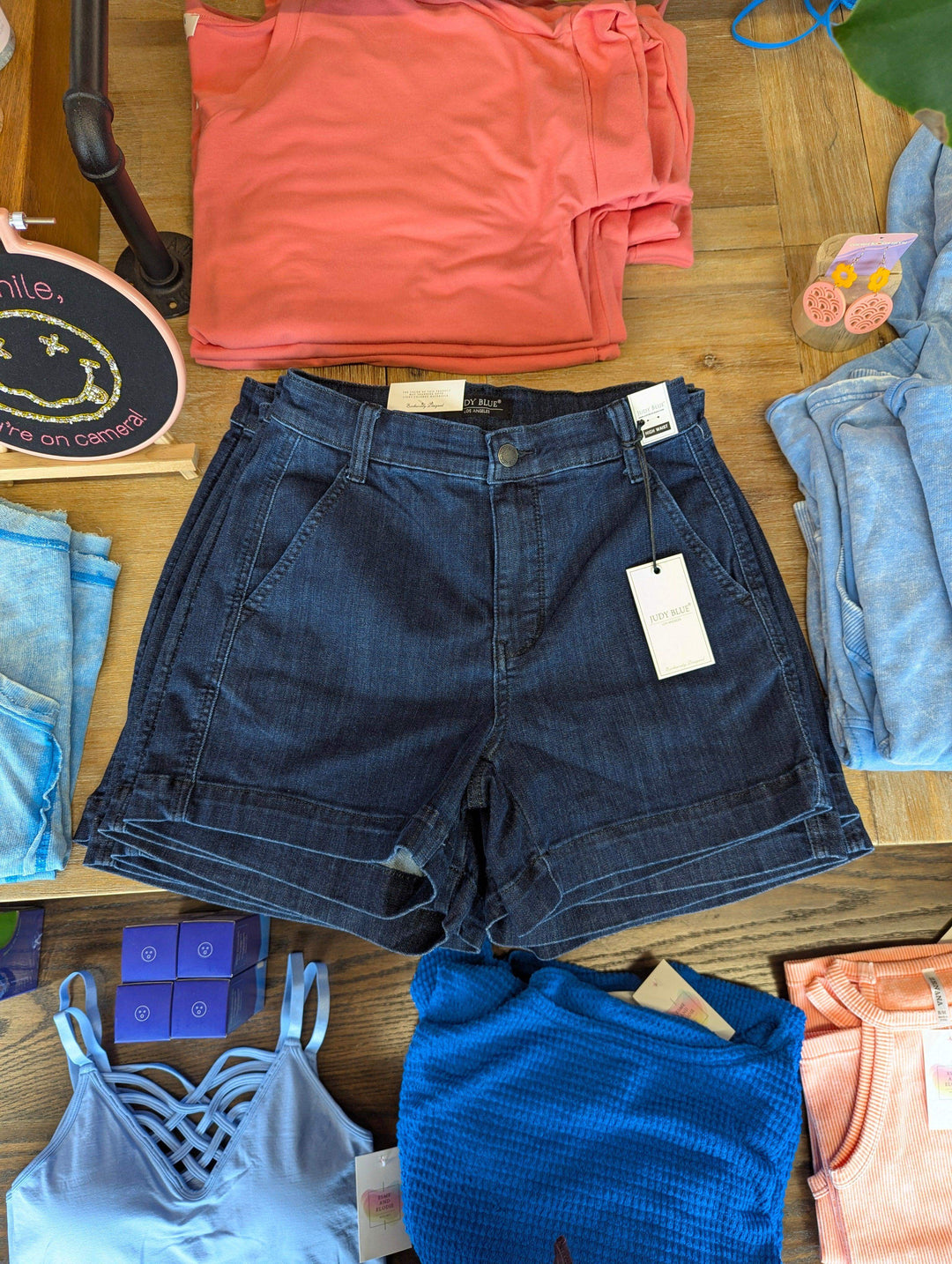 flat lay judy blue jeans dark wash on table with tank tops laid around it