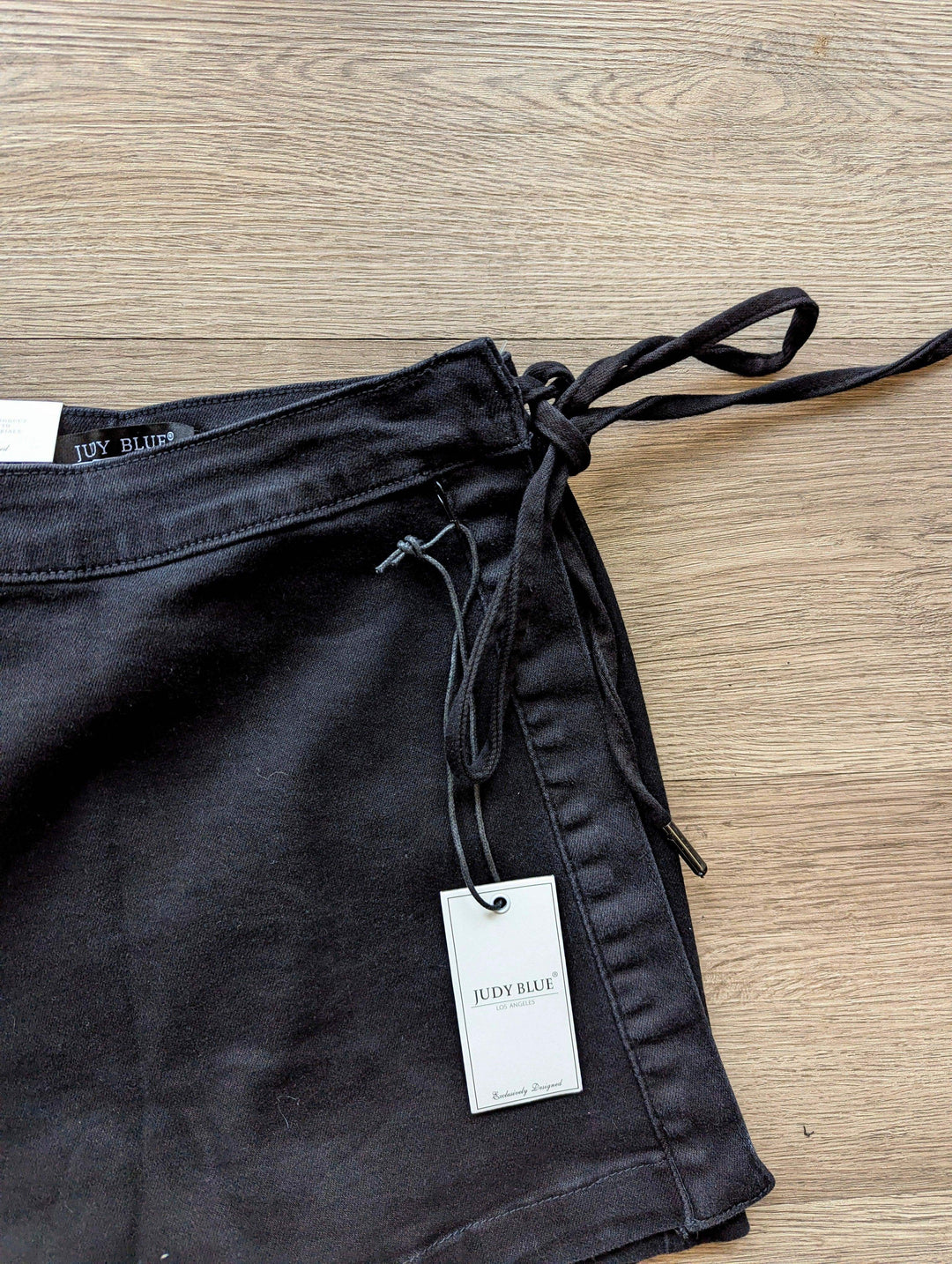 close up of tie on black judy blue skort laid on the floor