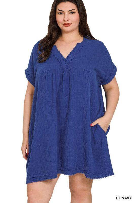 model wearing plus size v neck double gauze dress with hand in pocket in light navy blue