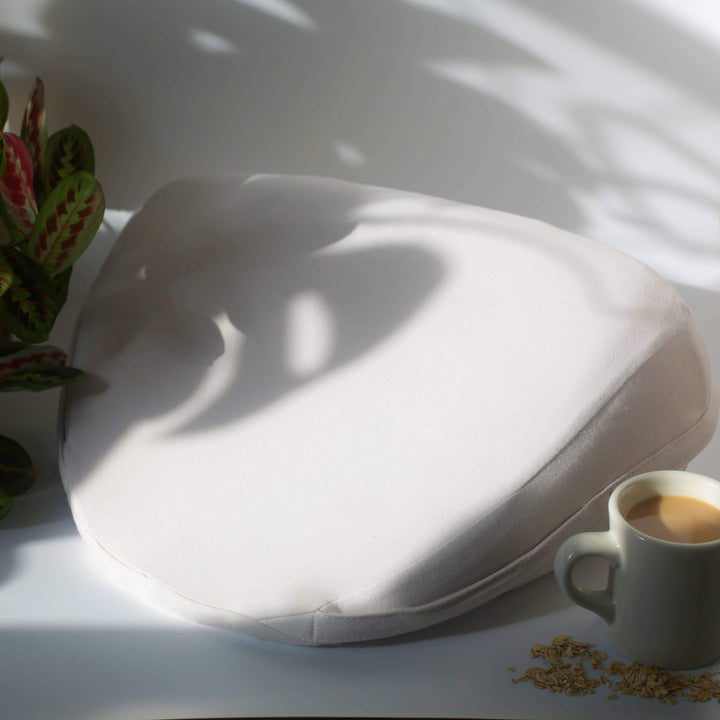lifestyle photo of dame wedges sex pillow with houseplant and coffee nearby