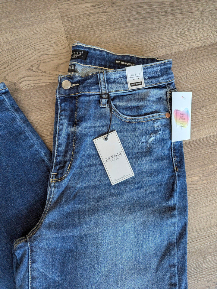 detail shot of waistband on jeans folded on floor to show the judy blue tag and pockets