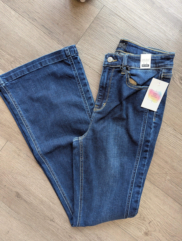 womens dark wash flare leg jeans folded in half and laying on floor 